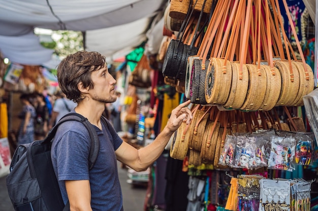 Uomo in un mercato di ubud bali tipico negozio di souvenir che vende souvenir e artigianato di bali al