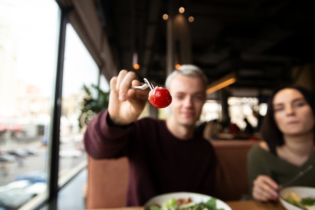 Uomo in un ristorante con un pomodoro