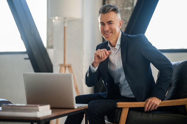 Uomo in un vestito elegante che lavora su un computer portatile