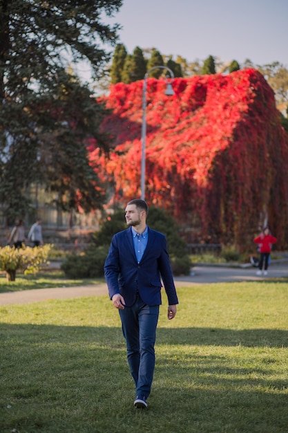 Uomo in un vestito in autunno nel parco