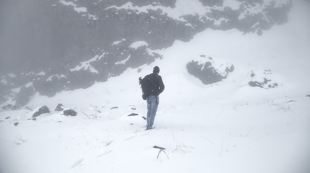 Uomo in uno zaino in inverno. Giornata nevosa