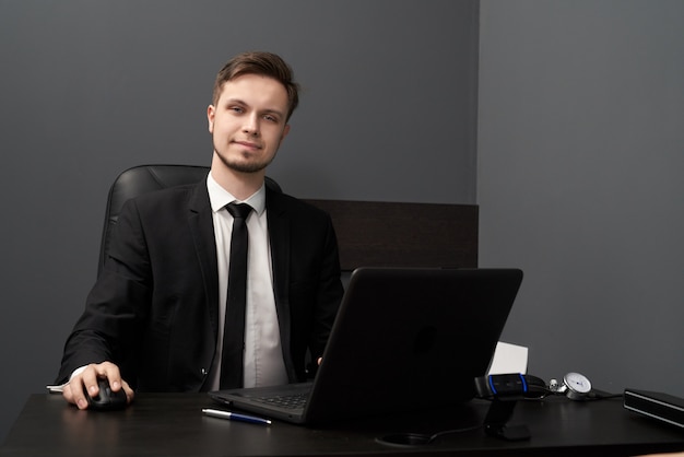 Uomo in vestito astuto che posa mentre lavorando con il rivelatore di bugia