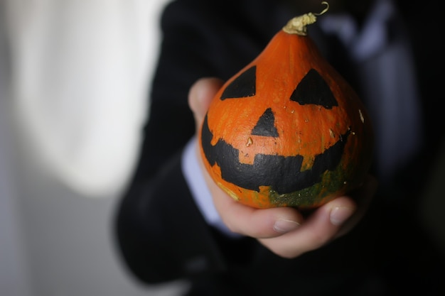 Uomo in vestito con il concetto di halloween della testa della zucca