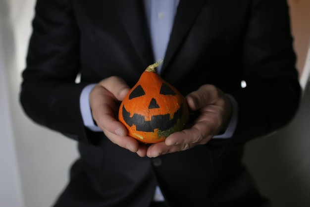 Uomo in vestito con il concetto di halloween della testa della zucca