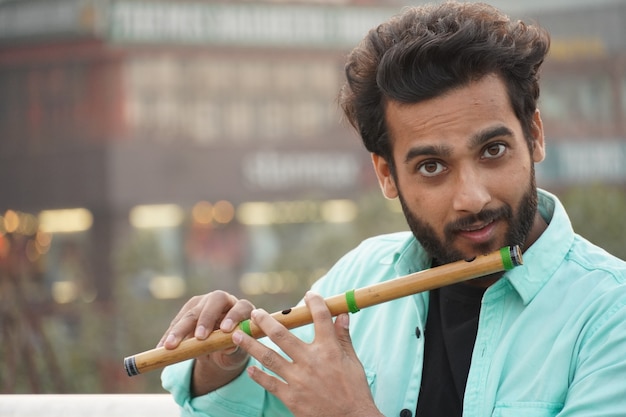 Uomo indiano che suona il flauto di bambù indiano bansuri