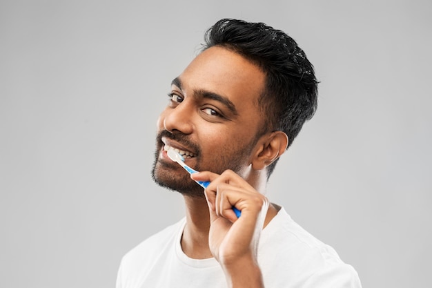 uomo indiano con spazzolino da denti che pulisce i denti