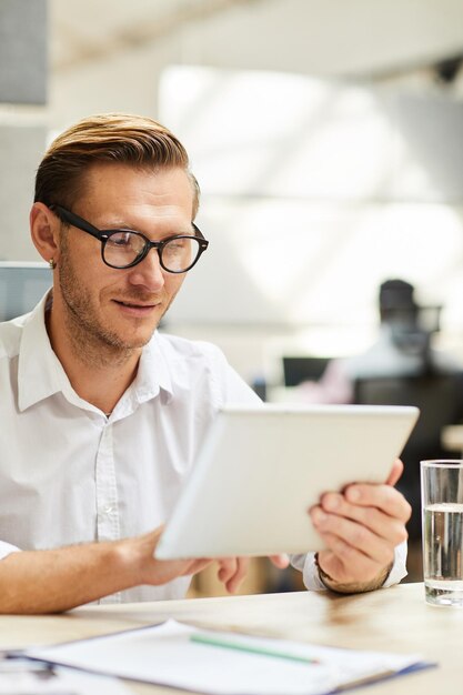 Uomo intelligente che utilizza tablet sul posto di lavoro