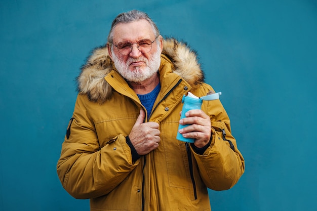 Uomo invecchiato serio in acqua potabile dei capispalla.