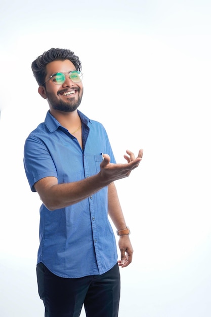 Uomo ispanico adulto su sfondo isolato stupito e sorridente alla telecamera mentre si presenta con la mano e punta con il dito