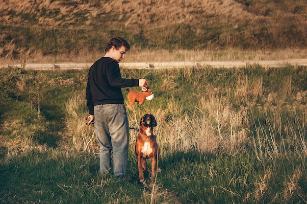 uomo la sera in una passeggiata fuori città con un cane