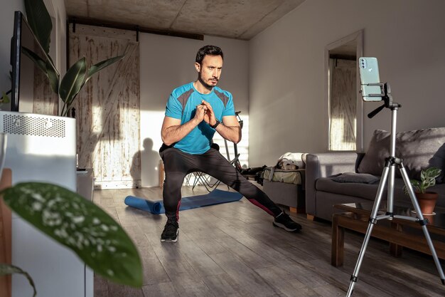 Uomo latino che realizza un video di fitness per i social media Creatore di contenuti per allenamenti di fitness online