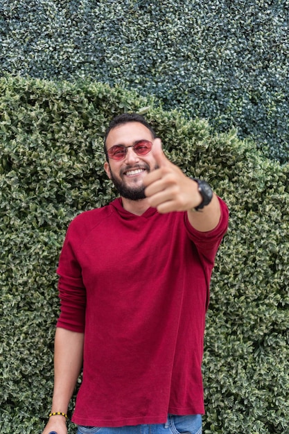 Uomo latino in camicia rossa che sorride alla macchina fotografica