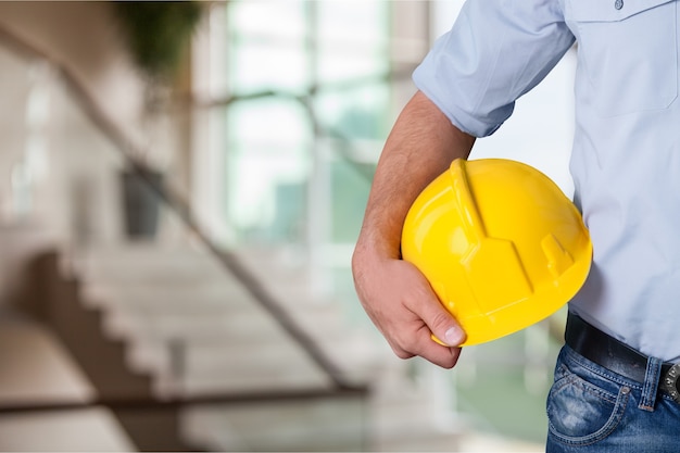 Uomo lavoratore con casco sullo sfondo