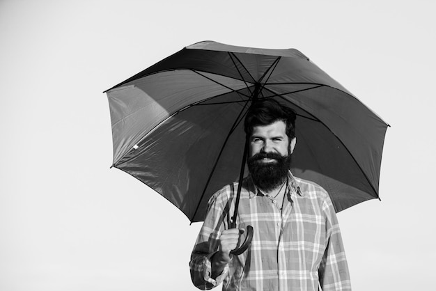 Uomo LGBT con ombrello arcobaleno capelli lunghi e barba Concetto Gay Pride LGBTQ isolato sul cielo