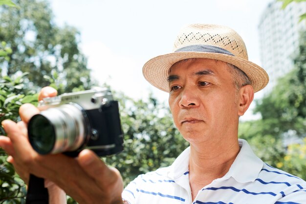 Uomo maggiore che guarda lo schermo della fotocamera