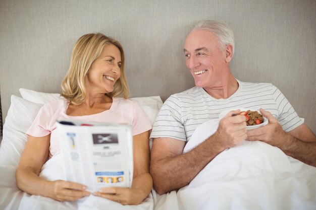 Uomo maggiore che mangia colazione a letto