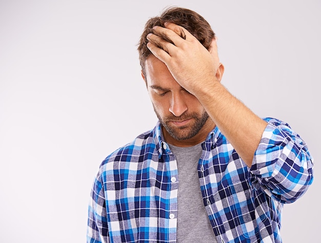 Uomo mal di mano e mal di testa dolore con stanchezza stress su sfondo bianco per emicrania burnout o spazio mockup Persona maschile ansia e nebbia cerebrale tensione in studio con vertigini salute benessere o vertigini