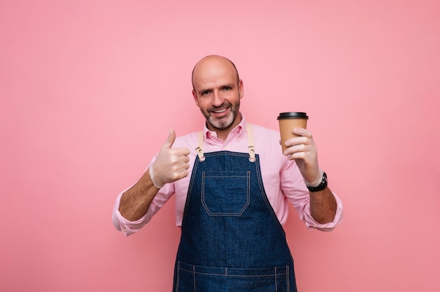 Uomo maturo calvo con il dito sull'espressione e caffè in tazza di cartone riciclabile