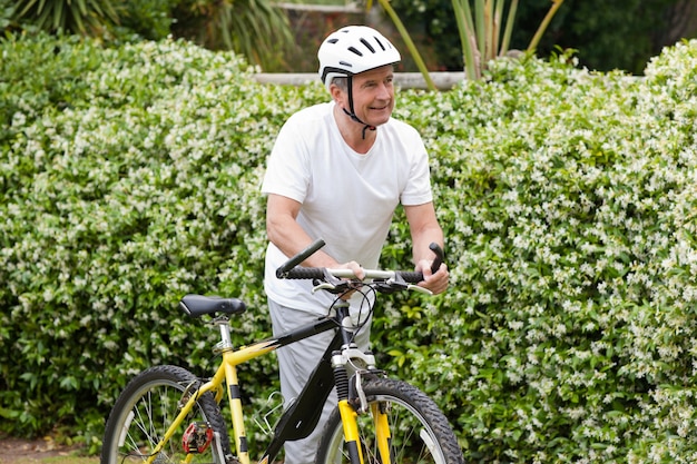 Uomo maturo che cammina con la sua mountain bike