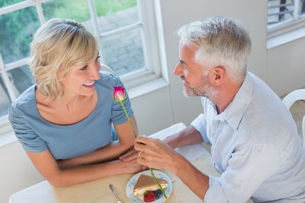 Uomo maturo che dà fiore ad una donna felice