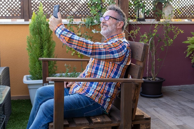 Uomo maturo che fa una videochiamata con il suo cellulare