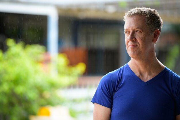 Uomo maturo che pensa mentre distoglie lo sguardo nelle strade all'aperto