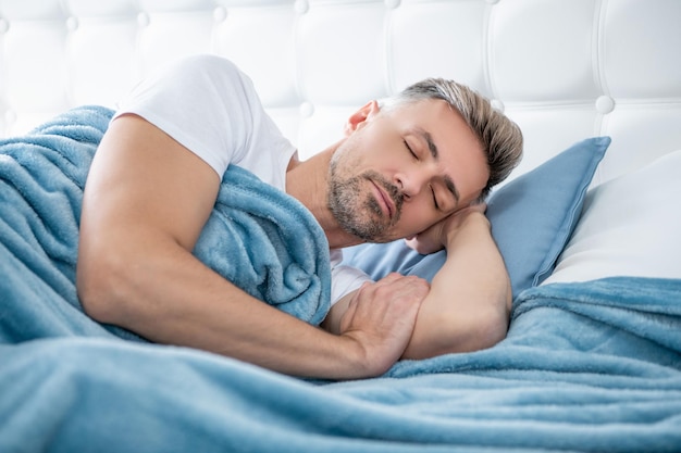 Uomo maturo che si rilassa a letto la mattina presto