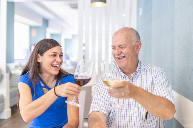 Uomo maturo e giovane donna che godono e che sorridono, trascorrendo del tempo insieme