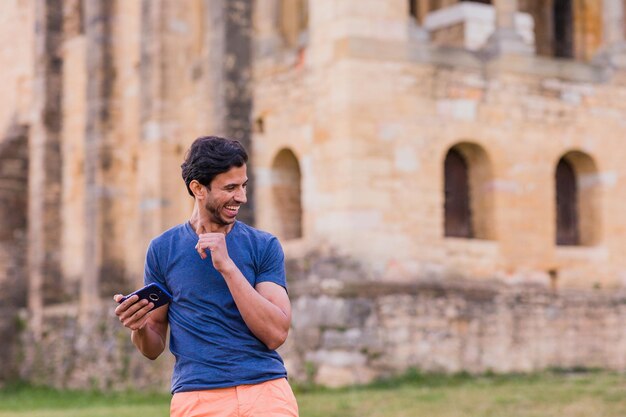 Uomo maturo modello indiano che balla Bollywood con musica per smartphone ritmo di viaggio in Europa su casual