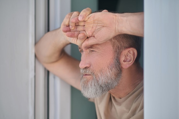 Uomo maturo pensieroso serio che guarda qualcosa