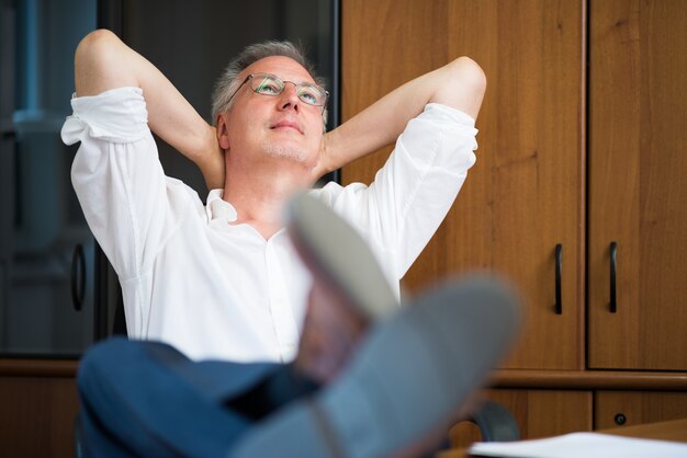 uomo maturo rilassante nel suo ufficio dopo il lavoro