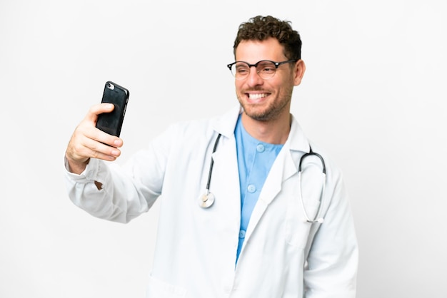 Uomo medico brasiliano su sfondo bianco isolato facendo un selfie