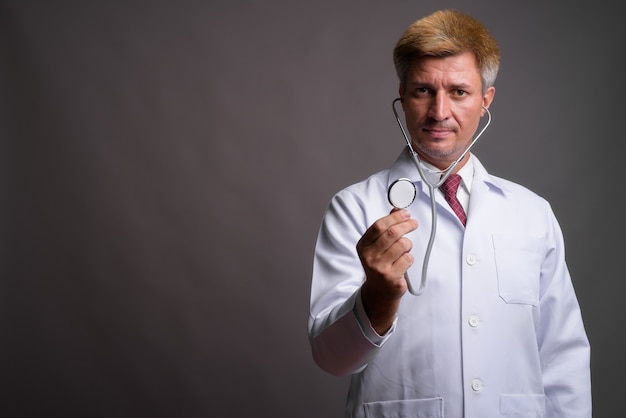 Uomo medico con capelli biondi utilizzando uno stetoscopio