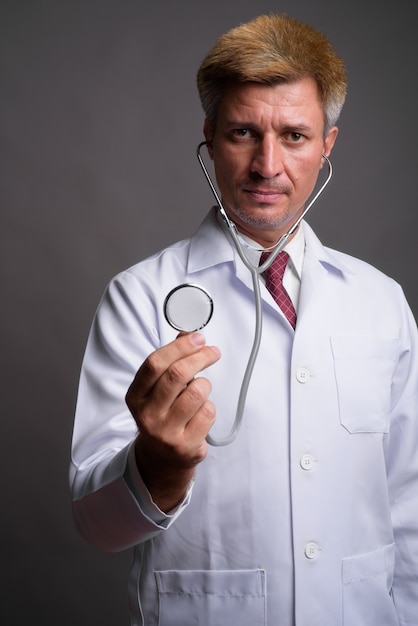 Uomo medico con capelli biondi utilizzando uno stetoscopio