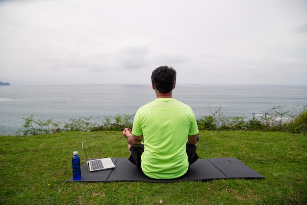 Uomo meditato vicino al mare Gli adulti praticano lo yoga sulla spiaggia al tramonto