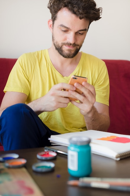 uomo moderno di hipster bello tramite cellulare