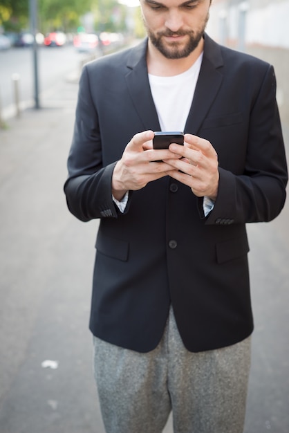 uomo moderno di hipster bello utilizzando smart phone