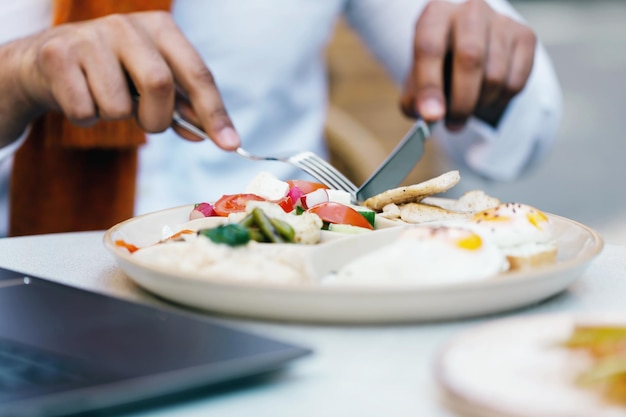 Uomo multiculturale che mangia cibo sano al caffè all'aperto