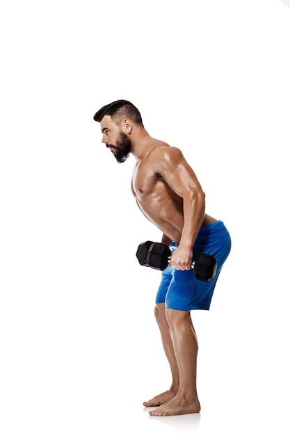 Uomo muscolare atletico che fa esercizi con manubri. Forte bodybuilder con torso nudo su sfondo bianco