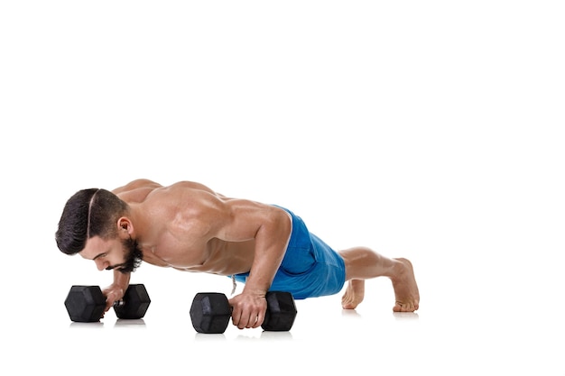Uomo muscolare atletico che fa esercizi con manubri. Forte bodybuilder con torso nudo su sfondo bianco