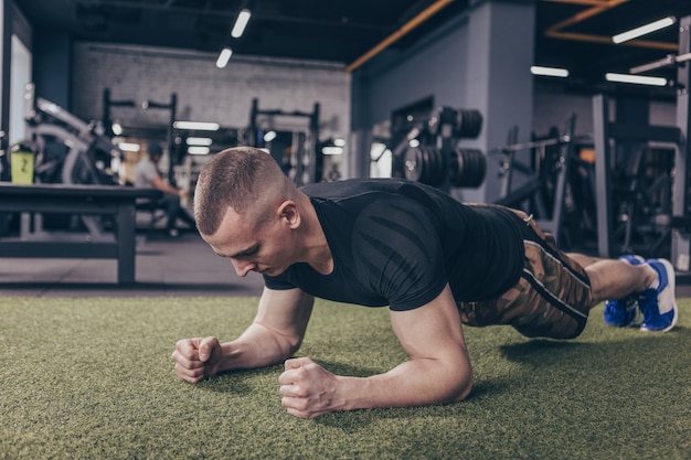 Uomo muscolare atletico che si esercita in palestra