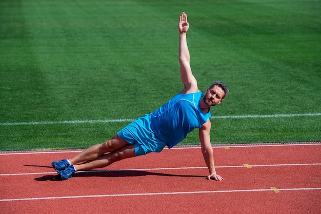 Uomo muscolare stare in tavola laterale che si estende su allenamento sportivo, yoga.