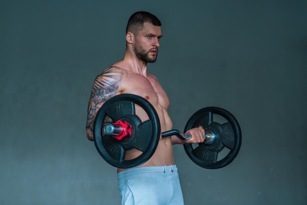 Uomo muscoloso allenamento in palestra uomo atletico con allenamento con i pesi in palestra bell'uomo con forza