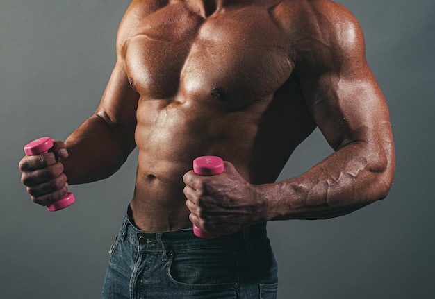 Uomo muscoloso fitness sexy corpo maschile in posa a torso nudo su sfondo grigio giovane atletico con nudo...
