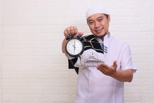 Uomo musulmano asiatico religioso che tiene promemoria dell'ora della sveglia per iftar durante il ramadan