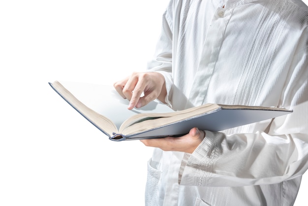 Uomo musulmano in piedi durante la lettura del Corano sulle sue mani