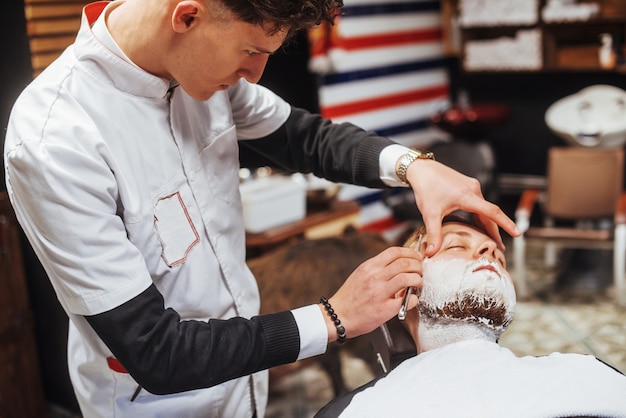 Uomo nel barbiere tagliatore di barba