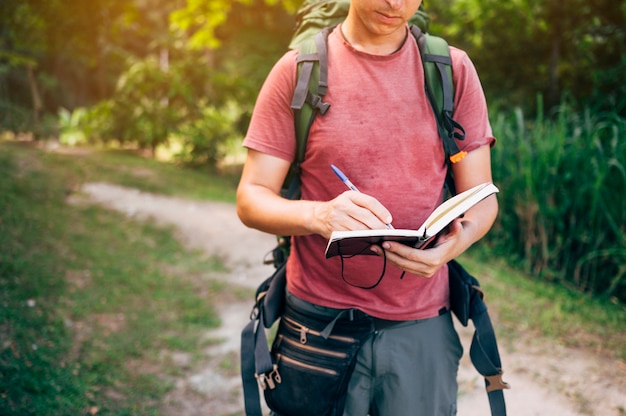 Uomo nella foresta scrivendo il suo diario