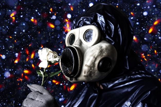 Uomo nella maschera antigas che tiene il fiore. Influenza delle radiazioni. Inquinamento ambientale. concetto di Chernobyl. Energia nucleare pericolosa. Disastro ecologico.