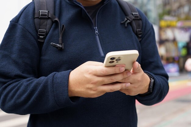 Uomo nella strada del centro città che ordina un taxi utilizzando l'app per smartphone Prenotazione taxi utilizzando l'applicazione online su smartphone